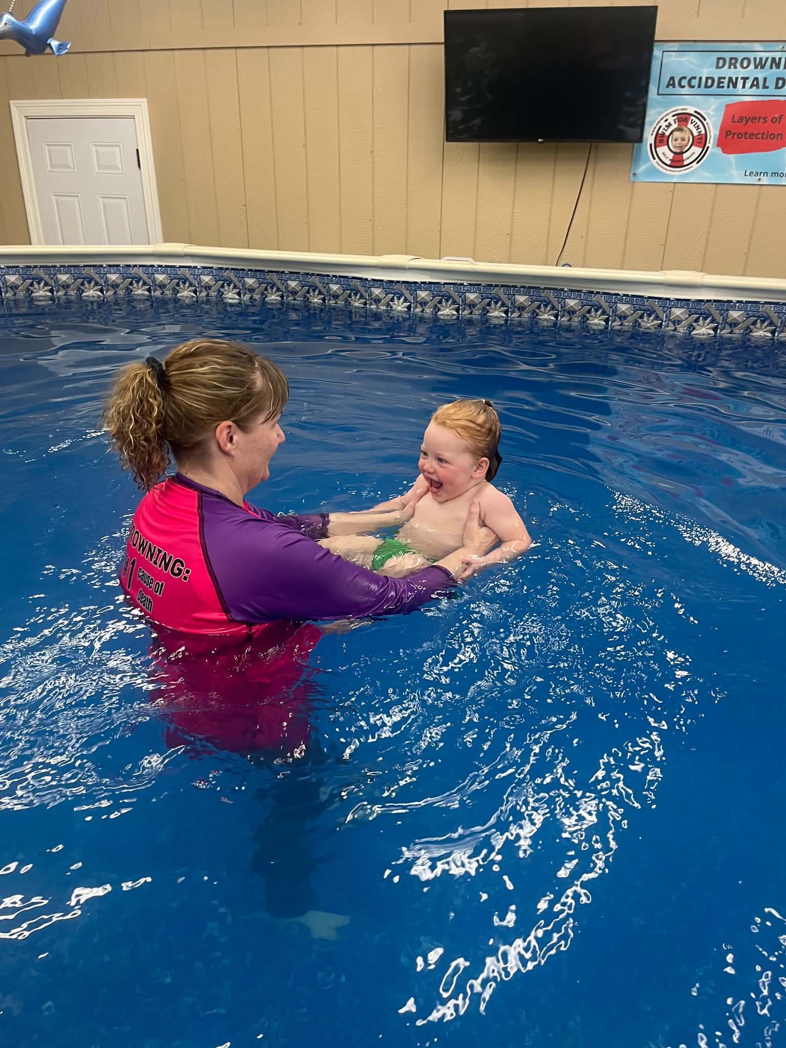 Daphne guiding an infant in an ISR survival swim lesson